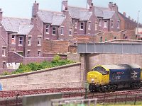 100 5094  Class 37 027 arrives “light engine” at Uphall. The stepped-terrace houses and the retaining wall are both from SCALESCENES