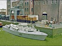 Picture9  Preserved motor torpedo boat 389 rests at the wharf on the canal. This is an unusual vessel to see on a model railway and adds to the variety of modelling. Meanwhile in the background a range of wagons wait to be loaded.
